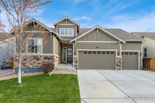 craftsman inspired home featuring roof with shingles, a front lawn, concrete driveway, an attached garage, and stone siding