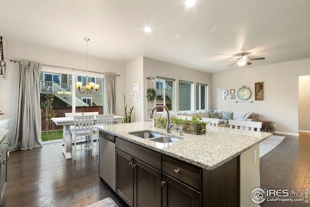 kitchen with dark brown cabinets, a sink, dishwasher, open floor plan, and dark wood-type flooring