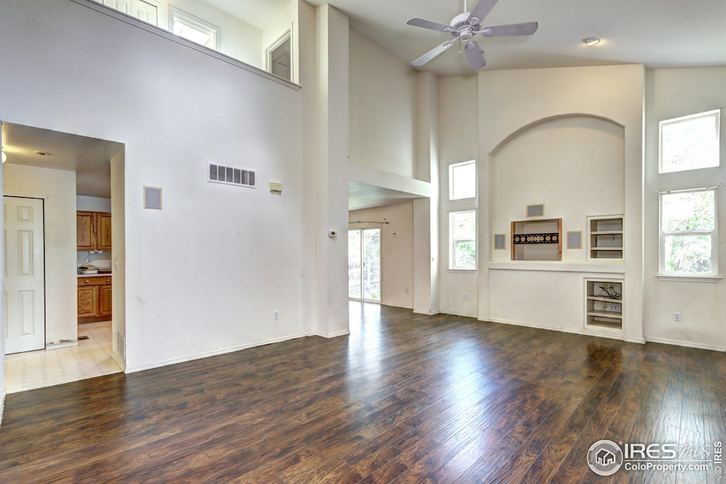 unfurnished living room featuring high vaulted ceiling, ceiling fan, wood finished floors, and visible vents