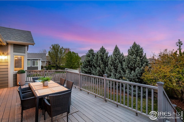deck at dusk featuring outdoor dining space