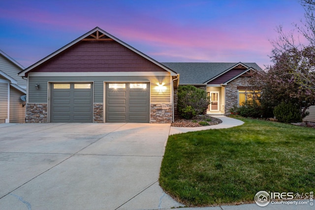 view of front of home featuring a yard, driveway, and stone siding