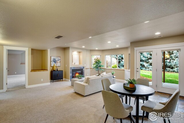 living room with visible vents, a fireplace, baseboards, light carpet, and recessed lighting