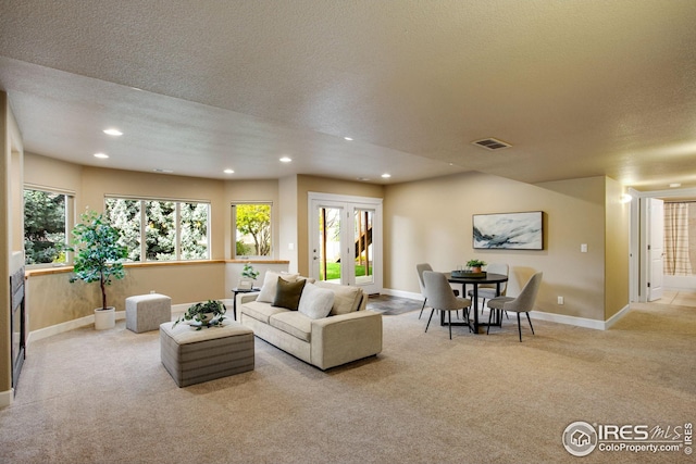 carpeted living area with visible vents, recessed lighting, baseboards, and a textured ceiling
