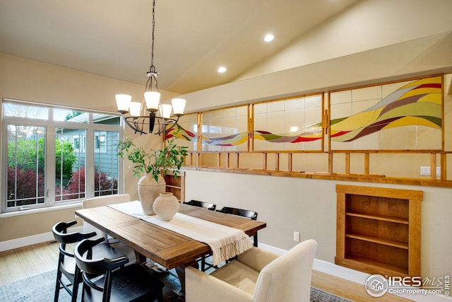 dining area with a notable chandelier, recessed lighting, baseboards, wood finished floors, and lofted ceiling