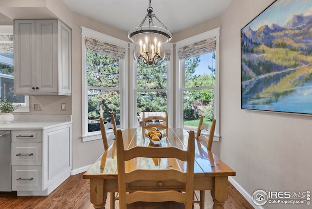 dining room featuring baseboards, a chandelier, and wood finished floors