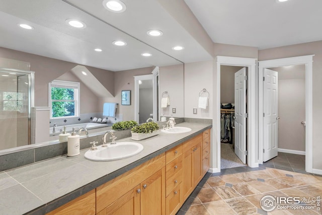 full bath featuring double vanity, a sink, a bath, and a shower stall