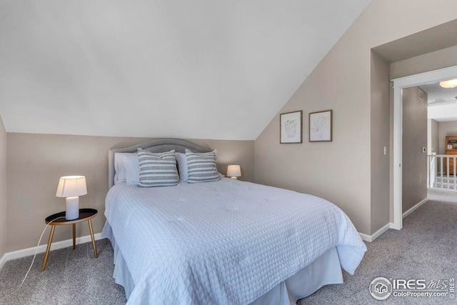 carpeted bedroom with baseboards and lofted ceiling