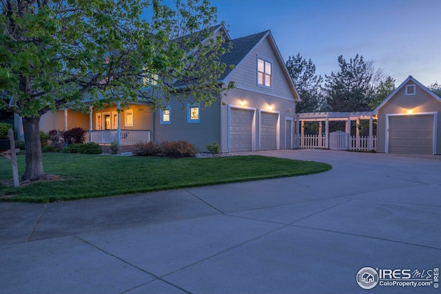view of front of home featuring a lawn, a garage, covered porch, and concrete driveway