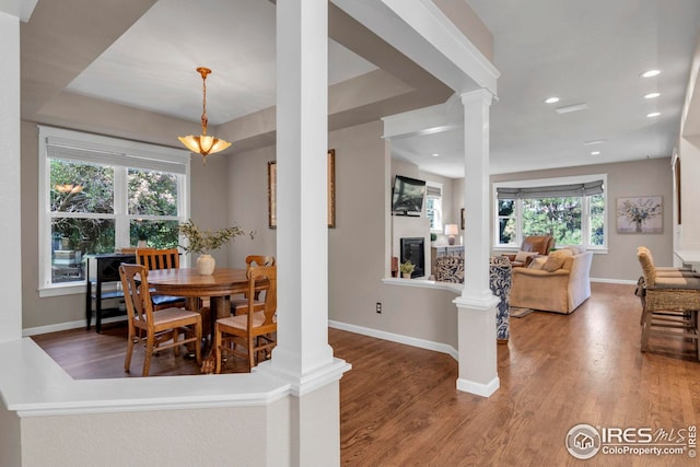 dining room featuring ornate columns, baseboards, recessed lighting, and wood finished floors
