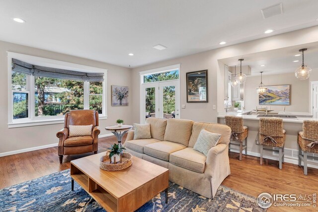 living room with baseboards, recessed lighting, wood finished floors, and visible vents