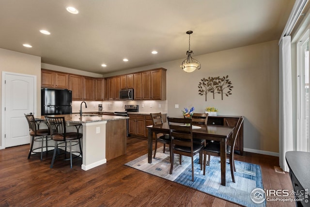 kitchen featuring recessed lighting, a sink, brown cabinets, and stainless steel appliances
