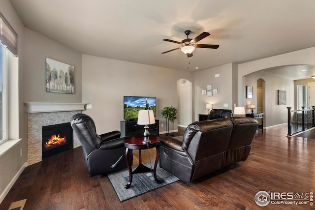 living room with arched walkways, ceiling fan, and wood finished floors
