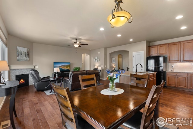 dining area featuring recessed lighting, arched walkways, ceiling fan, and dark wood-type flooring