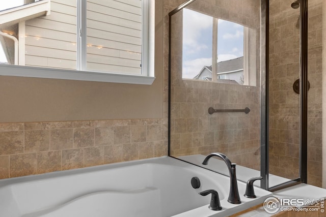bathroom featuring a garden tub and tiled shower