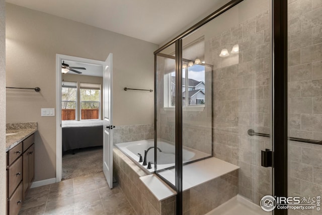 ensuite bathroom with ceiling fan, tile patterned flooring, a shower stall, vanity, and ensuite bath