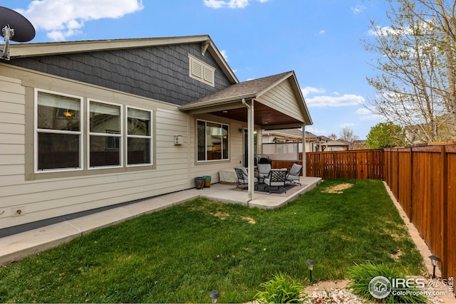 rear view of house featuring a patio, a fenced backyard, and a yard