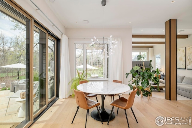 sunroom / solarium featuring a chandelier