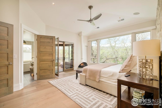 bedroom featuring access to outside, visible vents, wood finished floors, and lofted ceiling