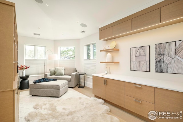 living area with visible vents, plenty of natural light, and light wood-style floors