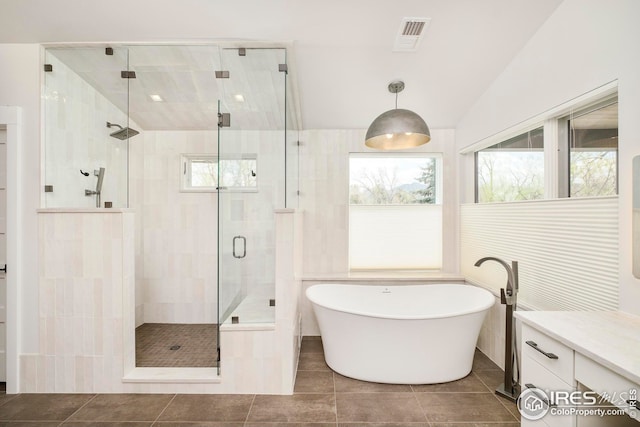 bathroom featuring vanity, a freestanding tub, a shower stall, lofted ceiling, and visible vents
