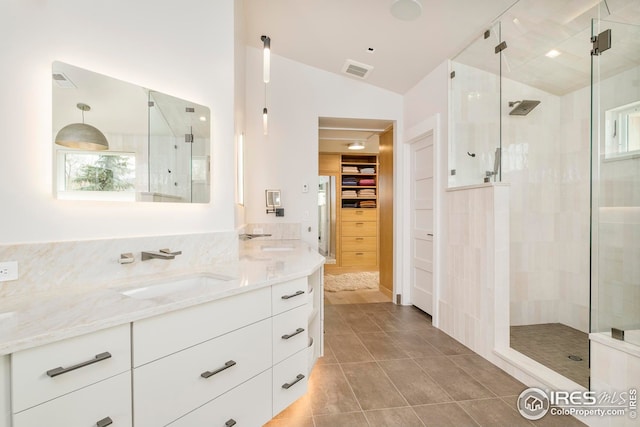 bathroom featuring vanity, a shower stall, vaulted ceiling, and visible vents
