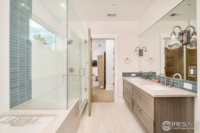 full bathroom with a sink, a stall shower, and visible vents