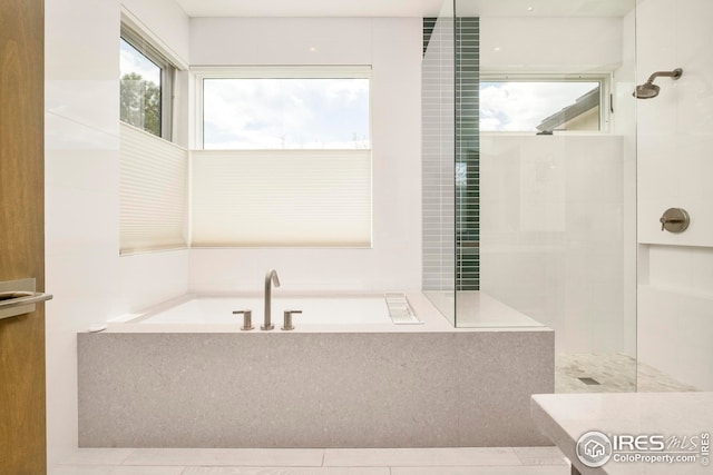 bathroom featuring a walk in shower and a tub to relax in