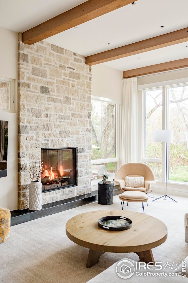living area with beamed ceiling and a fireplace