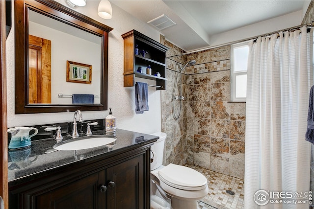 full bathroom featuring a textured wall, vanity, toilet, a shower stall, and visible vents