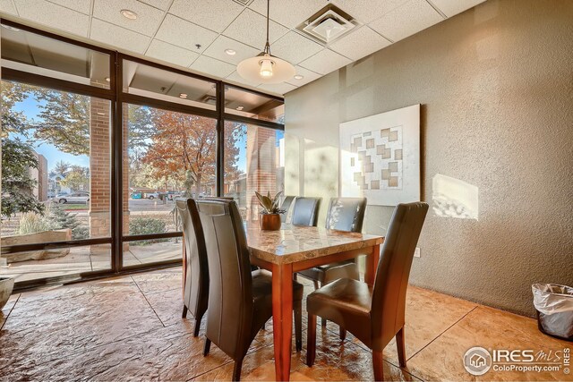 210 W Magnolia St Unit 320, Fort Collins, CO 80521 - dining space featuring a paneled ceiling, visible vents, expansive windows, and a textured wall