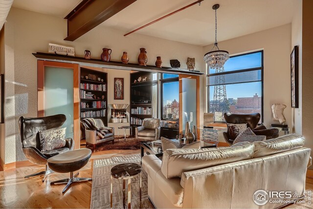 210 W Magnolia St Unit 320, Fort Collins, CO 80521 - living room with beamed ceiling, an inviting chandelier, and wood finished floors