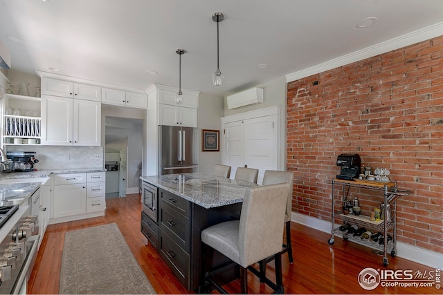 kitchen with white cabinets, open shelves, appliances with stainless steel finishes, light wood-type flooring, and a kitchen bar