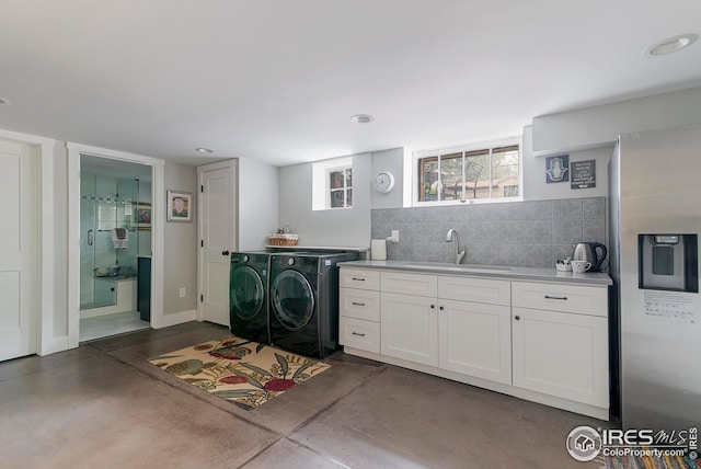 laundry area with a sink, washing machine and dryer, recessed lighting, and cabinet space