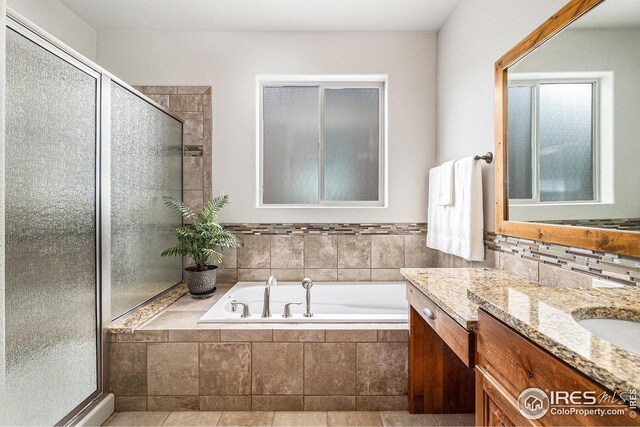 bathroom with vanity, a stall shower, and a garden tub