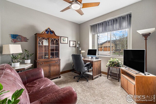 office area with baseboards, ceiling fan, and light colored carpet