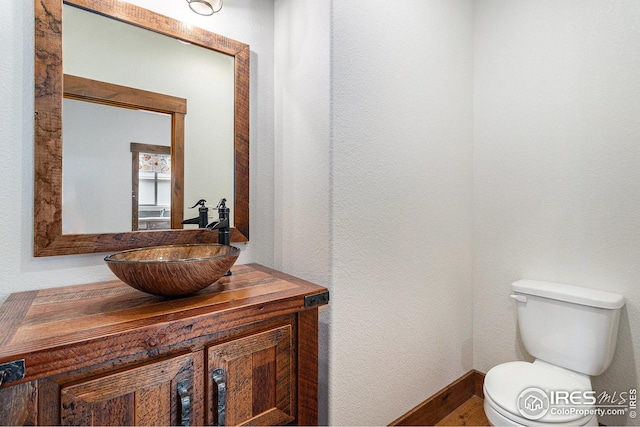 half bathroom with vanity and toilet