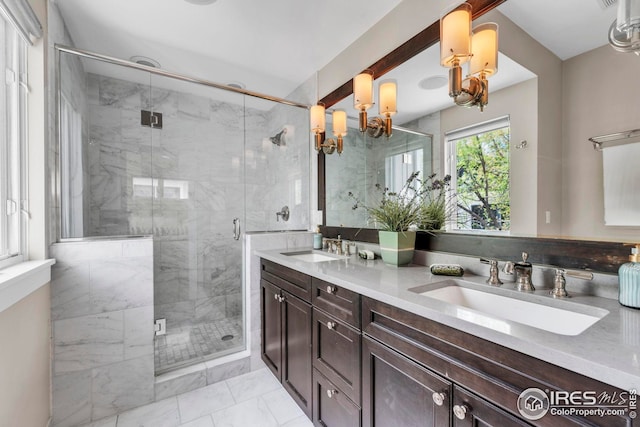 bathroom featuring double vanity, a sink, marble finish floor, and a stall shower