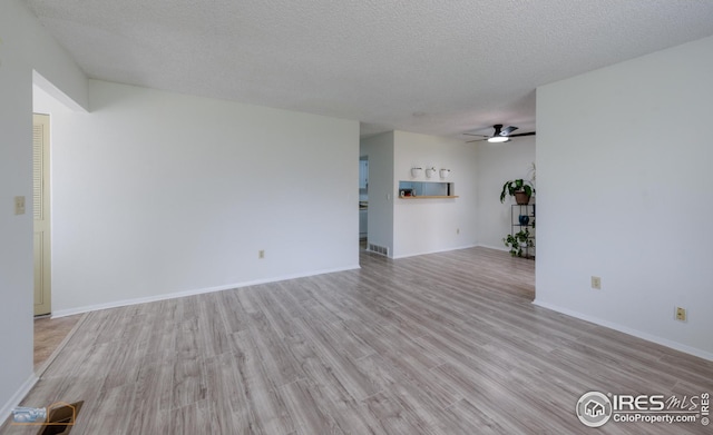 unfurnished living room with visible vents, light wood-style floors, baseboards, a textured ceiling, and a ceiling fan