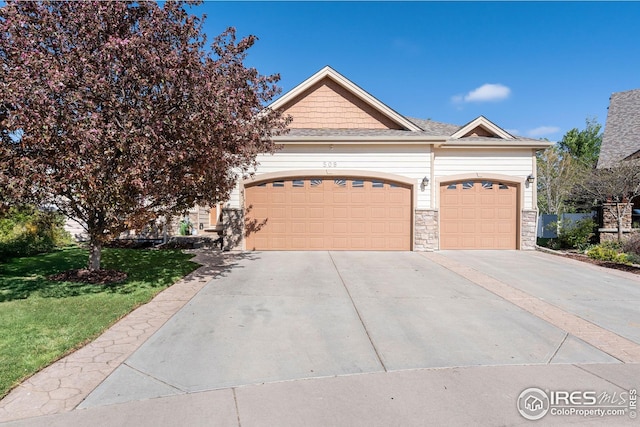 view of front facade with concrete driveway, a front yard, stone siding, and a garage