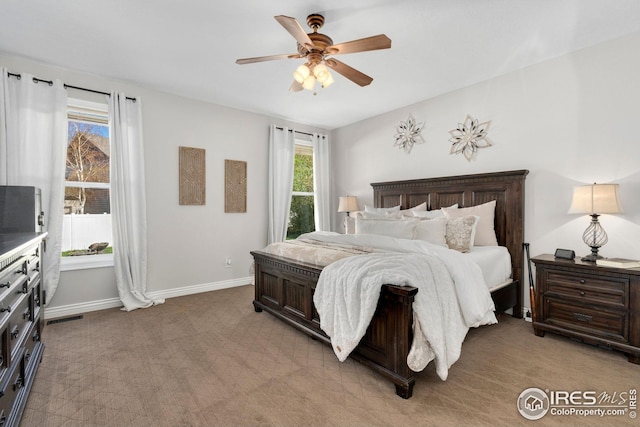 bedroom with baseboards, ceiling fan, visible vents, and light colored carpet