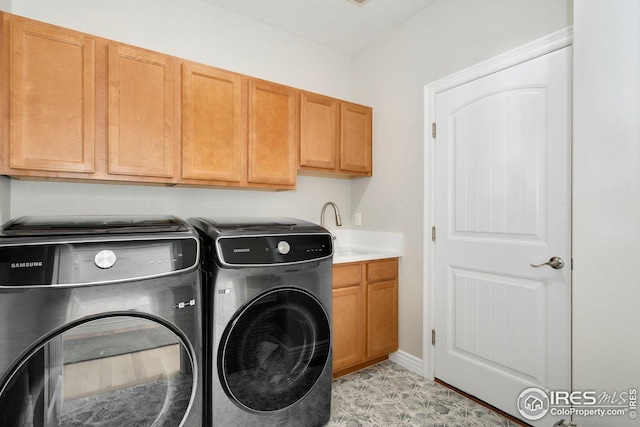 washroom with a sink, separate washer and dryer, and cabinet space