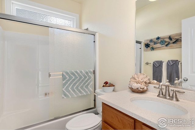 full bath with vanity, combined bath / shower with glass door, and toilet
