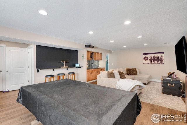 rec room featuring recessed lighting, baseboards, and light wood finished floors