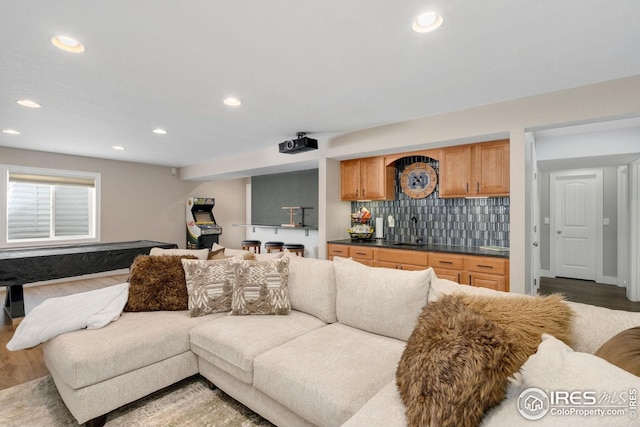 living area featuring recessed lighting, wet bar, and wood finished floors