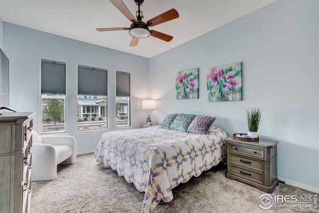 bedroom featuring light colored carpet, baseboards, and ceiling fan