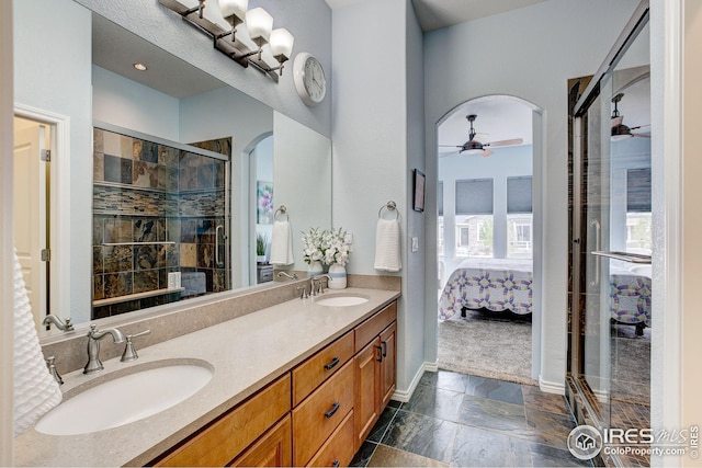 bathroom with a sink, a ceiling fan, ensuite bath, and double vanity