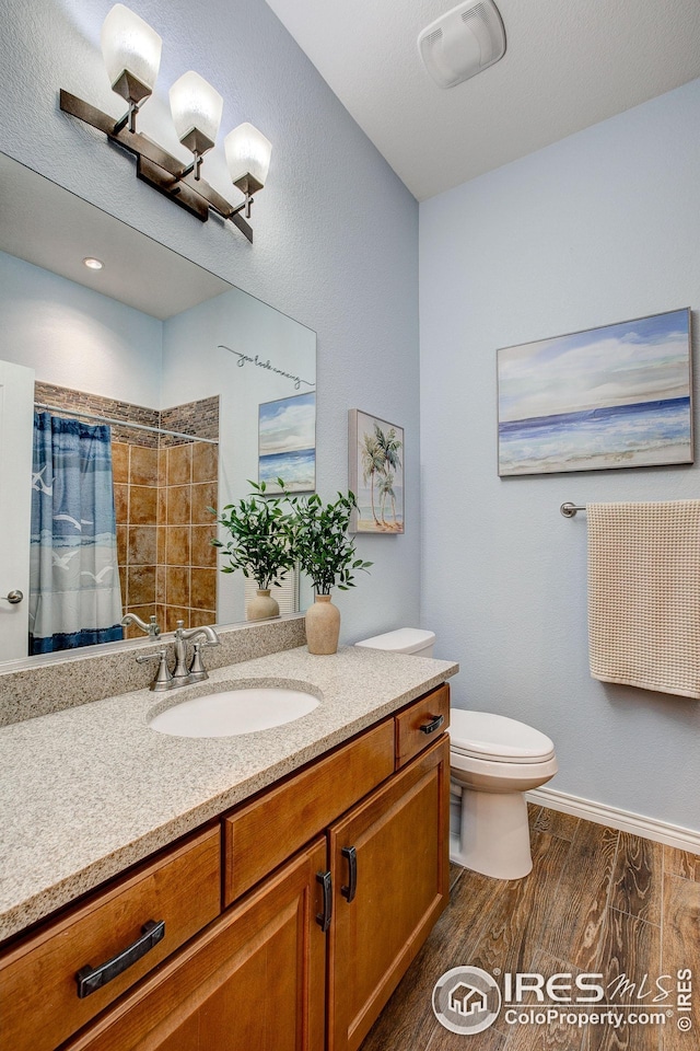 full bath featuring vanity, toilet, baseboards, curtained shower, and wood finished floors