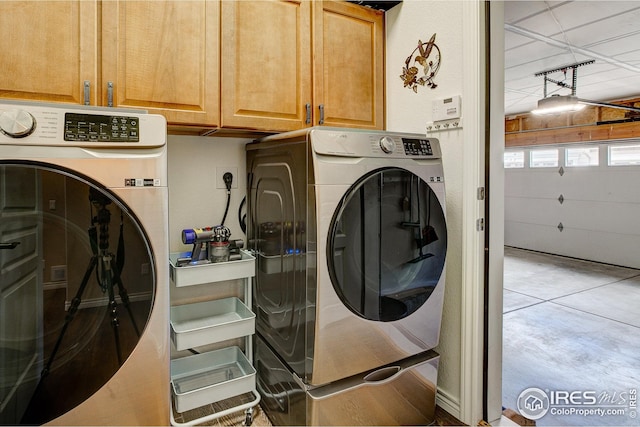 laundry room with washer and clothes dryer and cabinet space