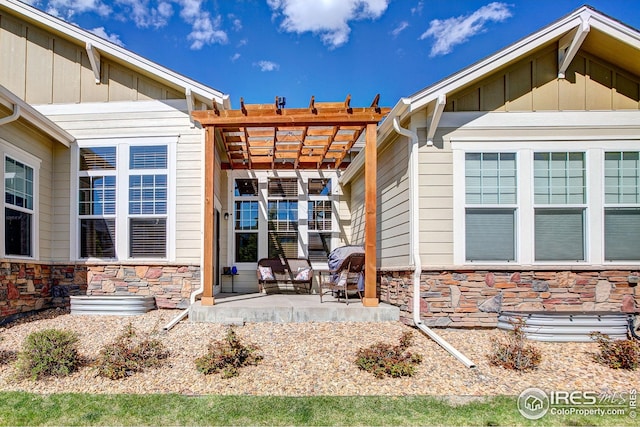 doorway to property featuring a pergola, board and batten siding, a patio, and stone siding