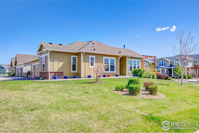 back of property featuring board and batten siding, a yard, driveway, and a garage